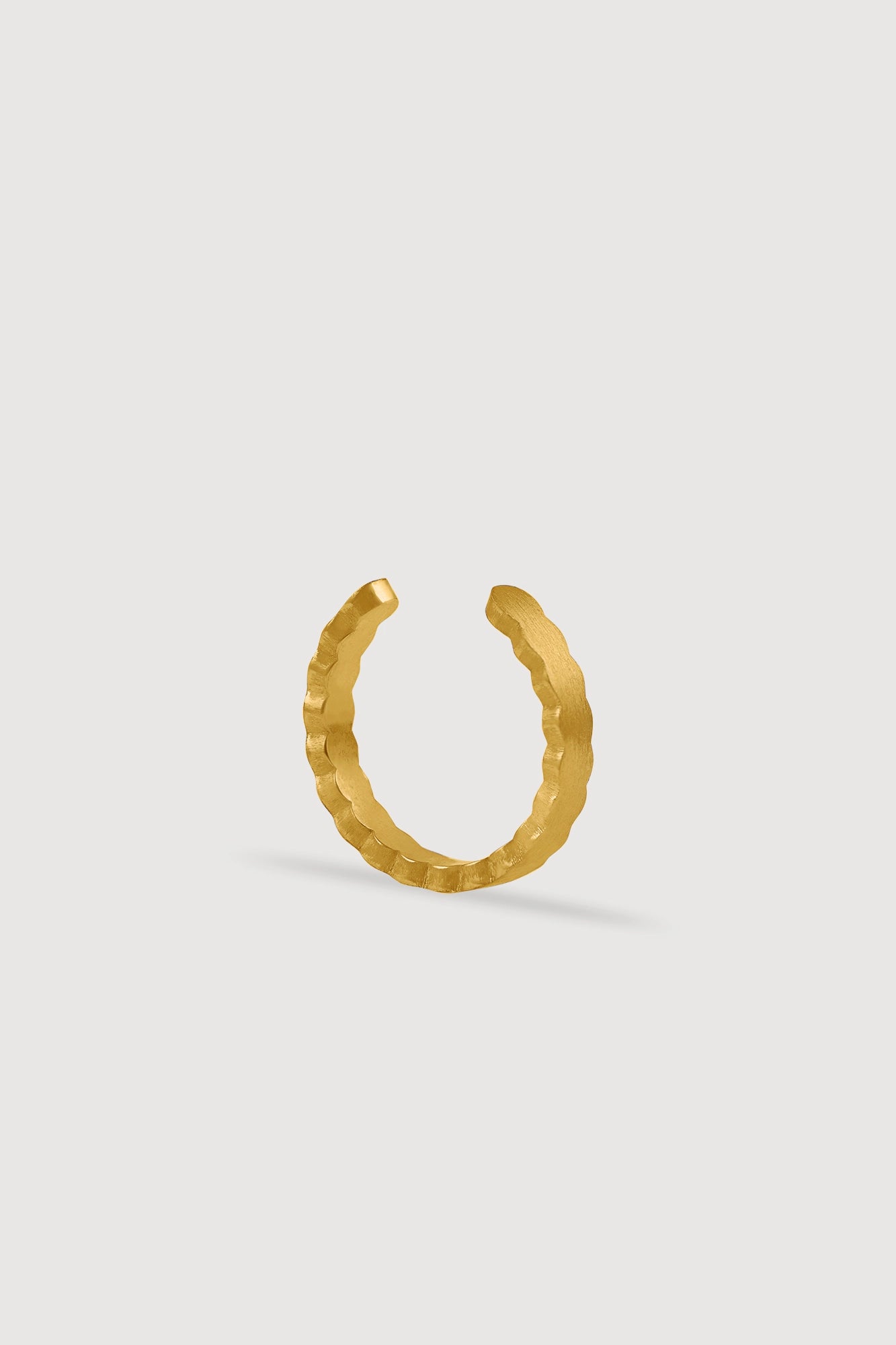 goldener Earcuff auf weißen Hintergrund