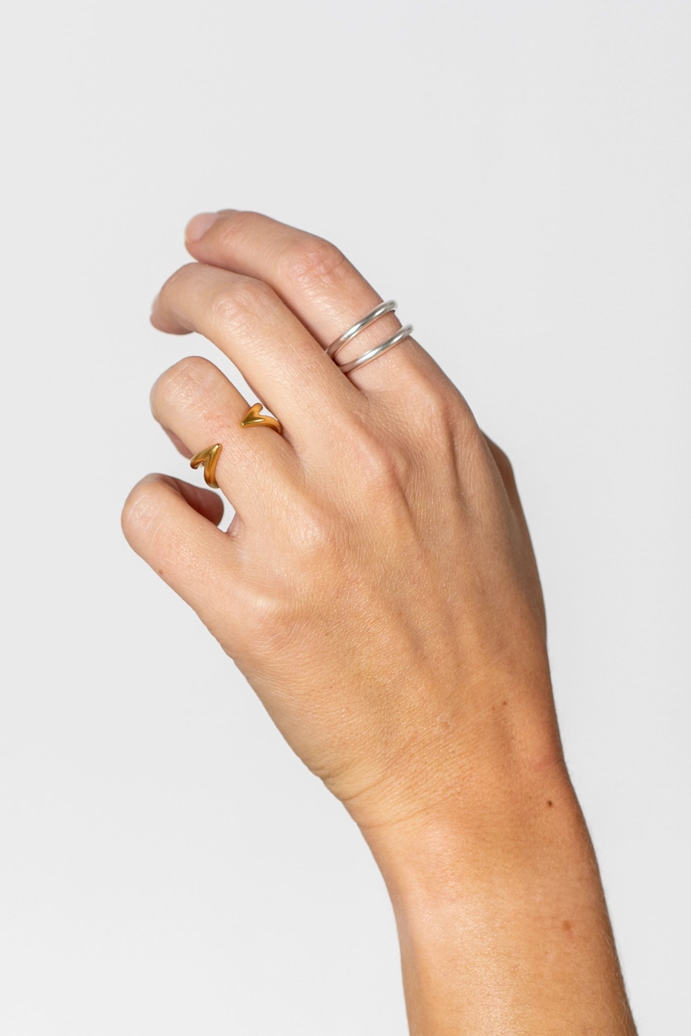 Hand mit silbernen Ring und goldenen Ring